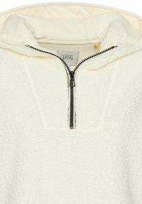 Weißer Fleece-Pullover mit einem Viertel-Reißverschluss, der eine strukturierte Oberfläche und ein weiches Innenfutter aufweist. Sichtbares Etikett: "camel active."