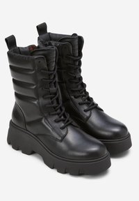 Schwarze Lederkampfstiefel bis zur Mitte der Wade mit einer robusten Sohle, Schnürverschluss und gepolstertem Kragen; verfügen über einen seitlichen Reißverschluss und strukturierte Akzente.