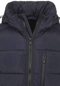 Marineblauwe pufferjack met kap, voorzien van een volledige ritssluiting en horizontaal gestikt ontwerp. Zwarte accenten en een merkinlabel aan de binnenkant.