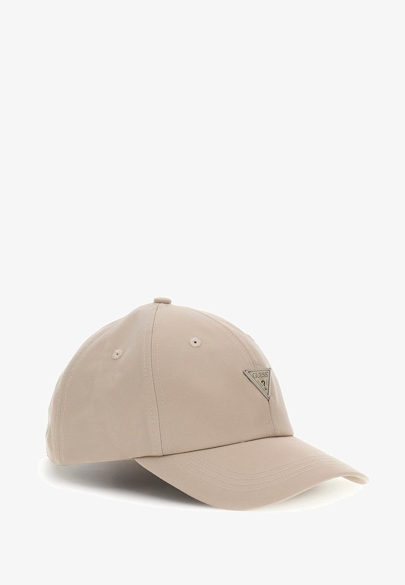 Beige baseball cap made of textured fabric, featuring a triangular metal logo patch on the front and stitched accents on the brim.