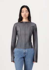 Gray long-sleeve top with a fitted design, smooth texture, panel detailing, and a square neckline, paired with blue denim jeans.