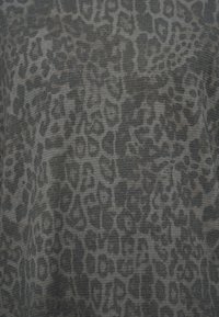 Ύφασμα με τύπωμα λεοπάρ, με υφή ραβδωτή επιφάνεια σε αποχρώσεις του γκρι και του μαύρου. Εμφανή ακανόνιστα μοτίβα σε όλο το υλικό.