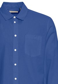 Blaue Button-up-Hemd mit spitzem Kragen, weißen Knöpfen und einer linken Brusttasche aus glattem Stoff.
