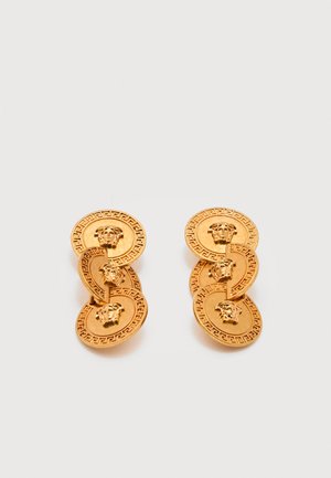 Orecchini dorati con tre medaglioni collegati, ciascuno decorato con una testa di Medusa e un bordo con motivo a meandro greco.