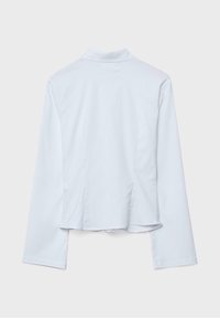 Bela dolgoročna jakna z visokim ovratnikom, vidnimi šivi in rahlo skrajšanim zadnjim robom na enobarvni svetlo sivi podlagi.