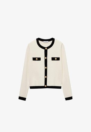 Kremni cardigan z črnimi robovi, okroglim izrezom in zlatimi gumbi. Ima dva črna žepa na sprednji strani. Mehka pletenina.