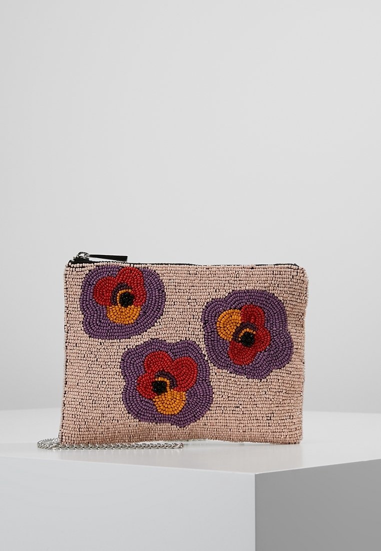 Pochette beige perlée avec des motifs floraux violets, rouges et oranges et une chaîne argentée, présentée sur une surface blanche.