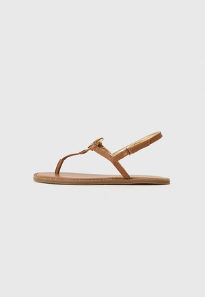 Sandalias de dedo de cuero marrón con un diseño de tiras delgadas, correa ajustable en el tobillo y suela plana con un detalle de costura decorativa.