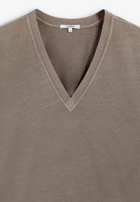 Camiseta de cuello en V de color taupe apagado, hecha de una tela suave y ligera con una textura lisa y detalles de costura mínimos.