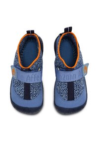 Niebieskie buty dziecięce charakteryzują się fakturowanym wierzchem z dzianinowym wzorem, elastycznym paskiem z logo oraz gumową podeszwą zapewniającą przyczepność. Widoczne pomarańczowe akcenty.