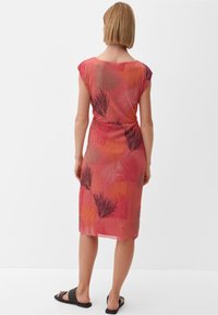 Vestido ajustado hasta la rodilla en rosa con patrones abstractos de hojas en negro y naranja. Tejido suave con un acabado texturizado y mangas cortas.