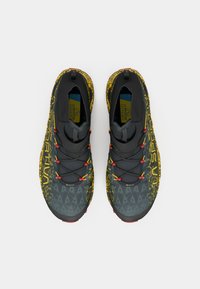 Pantofi de alergare pe traseu cu brâu gri, părți cu stropi galbeni, bucle de șireturi roșii și branding "La Sportiva", prezentati dintr-o vedere de sus pe un fundal alb.