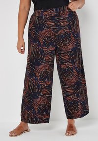Weite Hosen mit marineblauem Grund und einem wirbelnden Muster in Rost und Creme. Hergestellt aus einem weichen, leichten Stoff mit elastischem Bund.