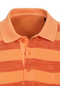 Pomarańczowa w paski koszulka polo z teksturowanej tkaniny, z klasycznym kołnierzykiem, dwubottonową listwą i kieszenią na piersi z detalem logo.