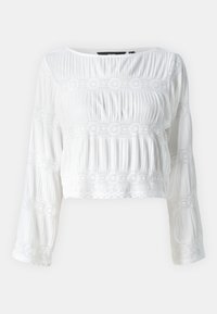Blusa bianca corta con maniche lunghe, caratterizzata da una texture plissettata e dettagli in pizzo sul petto e sulle maniche. Tessuto morbido e leggero.