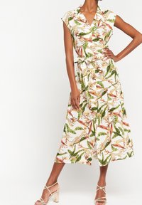 Sukienka w kwiatowy wzór na białym tle, z krótkim rękawem, z przodu zapinana na guziki, z paskiem w talii oraz pełną, do kolan spódnicą. Tkanina teksturowana.