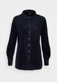 Camicia in corduroy blu navy con colletto, maniche lunghe e chiusura a bottoni; presenta una texture a righe verticali e cinque bottoni dorati scuri.