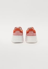 Suedesneakers med en rød-oransje og rosa fargekombinasjon. Har en plattformhvit såle og snøringsdesign med løkkeakenter på hælen.