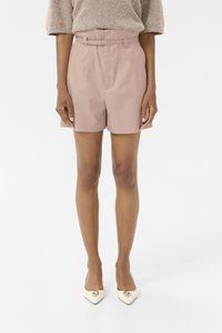 Lichtroze op maat gemaakte shorts met een riem, voorzien van plooien en een gladde textuur. Gewaard met crèmekleurige pumps met een spitse neus en een hartaccent.