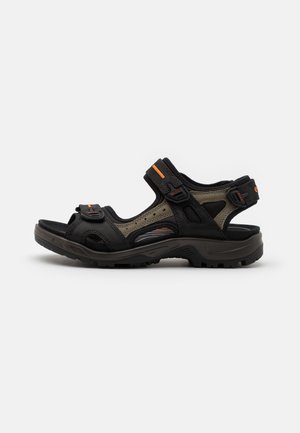 Black and olive green sandal featuring adjustable straps, breathable mesh panels, and a textured rubber sole for traction.