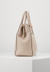 Beżowa skórzana torebka z teksturowaną powierzchnią, złotym suwakiem i kontrastującymi czarnymi szwami. Posiada dwa zaokrąglone uchwyty.