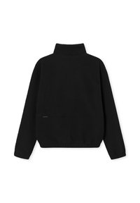 Čierna fleecová bunda s vysokým golierom, dlhými rukávmi a voľným strihom. Má textúrovaný povrch a elastický spodný lem.
