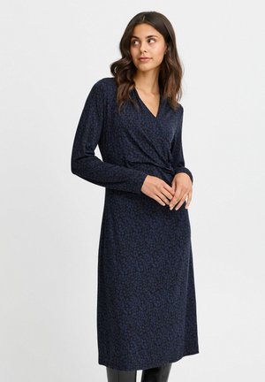 Navy blue wrap dress with long sleeves, featuring a subtle floral pattern. Made of soft material, with a v-neckline and gathered waist detail.