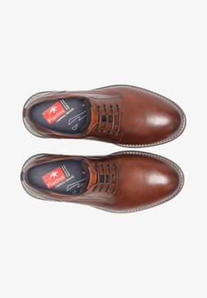 Zapatos de cuero marrón con punta redonda, diseño de cordones, costuras visibles y una plantilla texturizada que presenta el logo de Fluchos.