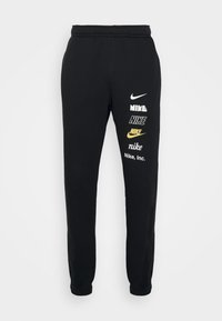 Pantalones deportivos negros con una cintura elástica, que presentan múltiples logotipos de Nike en blanco y dorado. Fabricados con un tejido suave y texturizado.