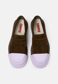 Hnědé nubukové slip-on boty s levandulovou gumovou špičkou, které mají dekorativní přední klapku a červené logo "CAMPER" uvnitř.