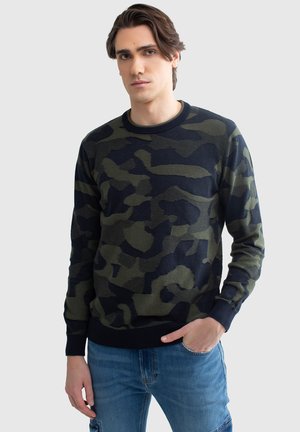 Bluza w kamuflażu w ciemnozielonym i granatowym kolorze, z okrągłym dekoltem, ściągaczami przy rękawach i teksturowanym materiałem z wzorem nieregularnych kształtów.