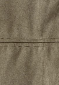 Tessuto in faux suede verde oliva con una superficie morbida e texturizzata. Presenta una cucitura centrale per un dettaglio in più. Aspetto liscio e uniforme.
