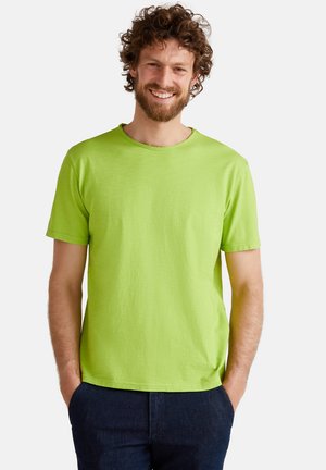 Camiseta de manga corta y cuello redondo en algodón verde brillante. Textura suave con un corte relajado y sin patrones ni logotipos visibles.