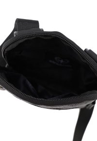 Borsa nera con chiusura con zip. Esterno liscio, texture in tessuto, interno con fodera scura. Cinghia attaccata per la comodità del trasporto.
