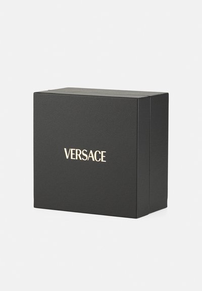 Must-haves mööbel musta ruudu karbiga, mis on valmistatud tekstuuriga materjalist, millel on ees kuldne "VERSACE" logo. Lihtne disain teravate servadega.