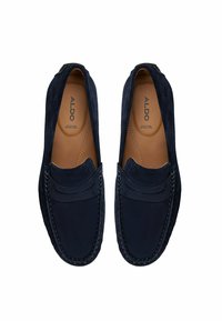 Mocassini in suede blu navy con finitura liscia, caratterizzati da dettagli cuciti e una punta stile mocassino leggermente rialzata. Logo del marchio visibile all'interno.