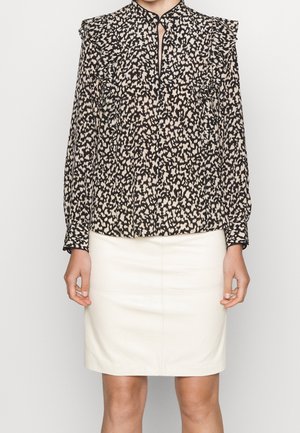 Sort og beige bluse med abstrakt mønster, flæser på skuldrene, nøglehul-nedskæring og lange ærmer, parret med en cremefarvet blyantskørt.