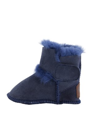 Marineblauem Wildlederstiefel mit Kunstfellbesatz, der mit einem Klettverschluss befestigt ist. Verfügt über eine strukturierte, genähte Sohle und ein kleines braunes Logo-Highlight an der Seite.