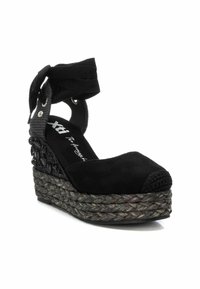 Sandalias de cuña negras con parte superior de gamuza, suela de yute trenzado y acentos decorativos de cristales negros. Cuenta con cintas para atar en el tobillo.