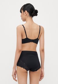 Black lingerie set featuring a fitted bralette with adjustable straps and lace-trimmed high-waisted panties with floral lace accents.
