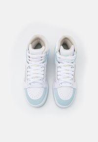 Paire de baskets montantes blanches et bleu clair avec lacets, col rembourré et bout perforé, vues de dessus sur fond blanc.