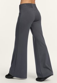 Graue, weit geschnittene Hosen mit einem strukturierten, elastischen Bund, hergestellt aus weichem Stoff, mit einem lässigen Schnitt und minimalen Details.