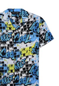 Camicia a maniche corte con una stampa di graffiti colorata, con accenti blu, neri e gialli su uno sfondo bianco. Design con colletto.