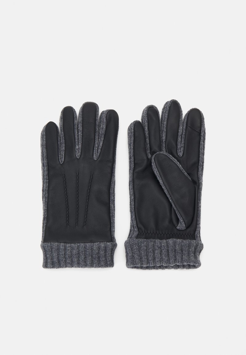 Gants en cuir noir avec des poignets tricotés gris, présentant trois accents cousus sur le côté de la paume, offrant un contraste de texture et de couleur.