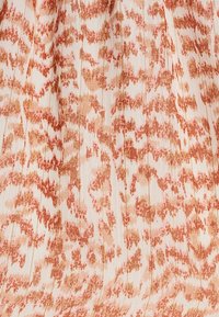 Virtaava kangas, jossa on vaalea pohjaväri, ja siinä on teksturoitu, abstrakti kuvio korallin ja pehmeän oranssin sävyissä. Korostuksina on pystypleat.