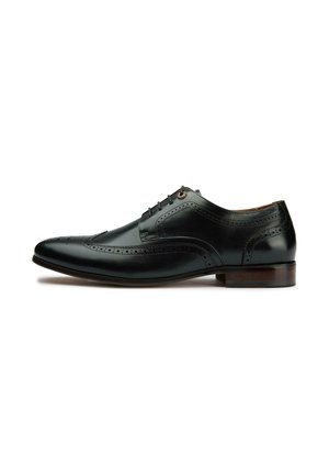 Black leather Oxford shoe with perforated detailing, rounded toe, and laces. Features a wooden heel and smooth texture.