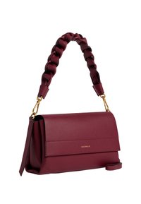 Borsa a mano in pelle bordeaux con manico intrecciato, hardware dorato, chiusura a patta e logo Coccinelle sul davanti.