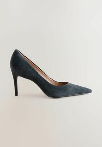 Sandaali korkealla kantapäällä, teräväkärkinen, tummanharmaasta mokasta, jossa on sulavalinjainen muotoilu, sileä pinta ja kapea stiletto-kenkä.