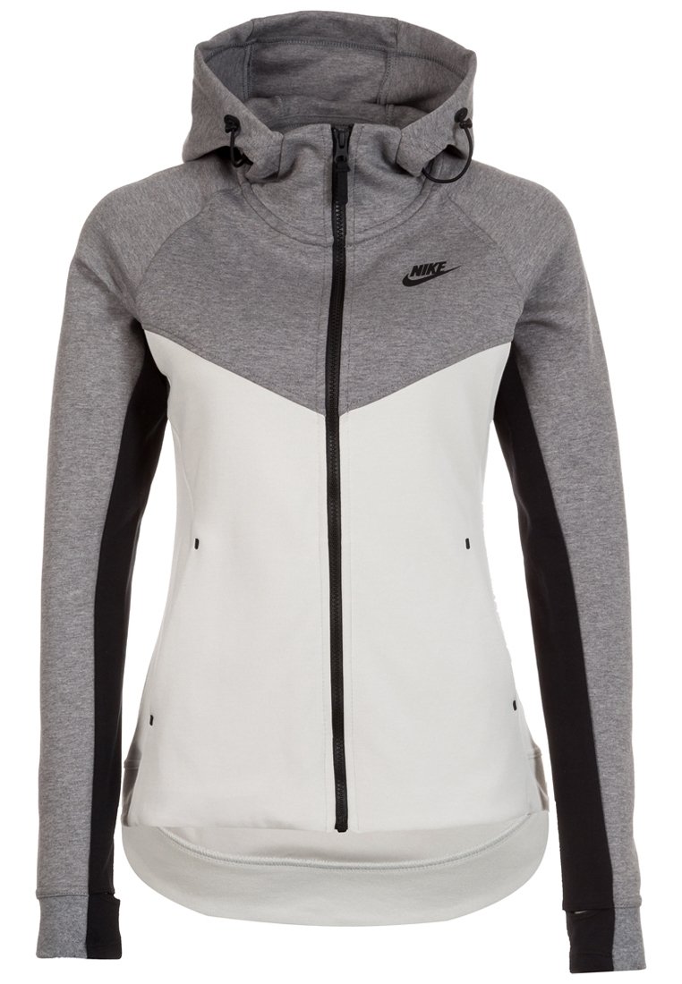 Nike mikina s kapucí s šedobílo blokovým designem, plným zipem a jemně strukturovaným materiálem. Obsahuje nastavitelnou kapuci se šňůrkou.