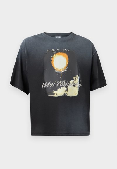 Μαύρο κοντομάνικο μπλουζάκι με γραφικό ενός πορτοκαλί και λευκού ήλιου και σύννεφων, με το κείμενο «Won Hundred» στο σ τήθος.